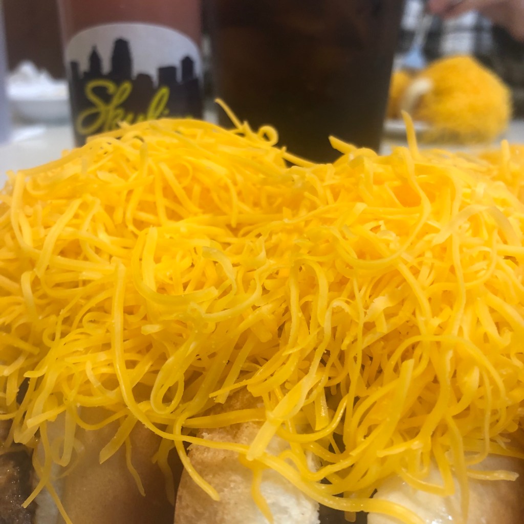 Close up shot of a pile of cheese on a Skyline coney.